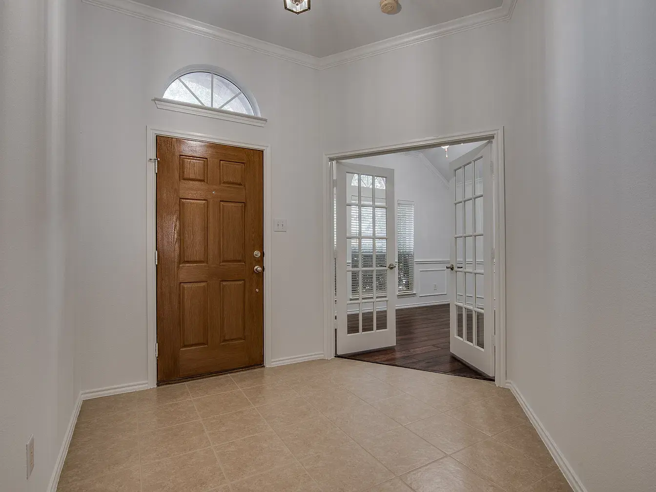 Entry with arched transom and French doors to the office