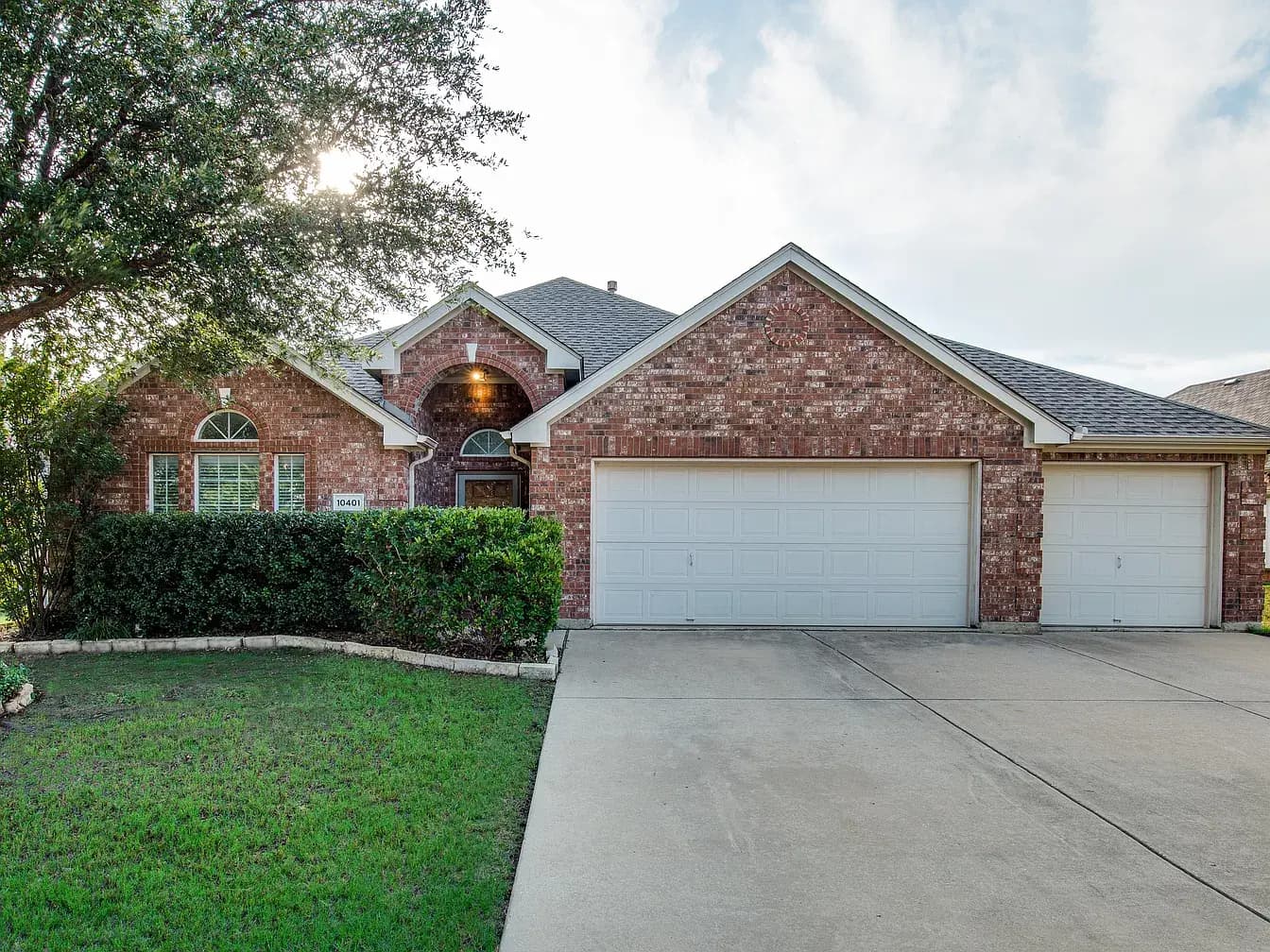 Front of 10401 Vintage Drive: brick single-story home with a three-car garage