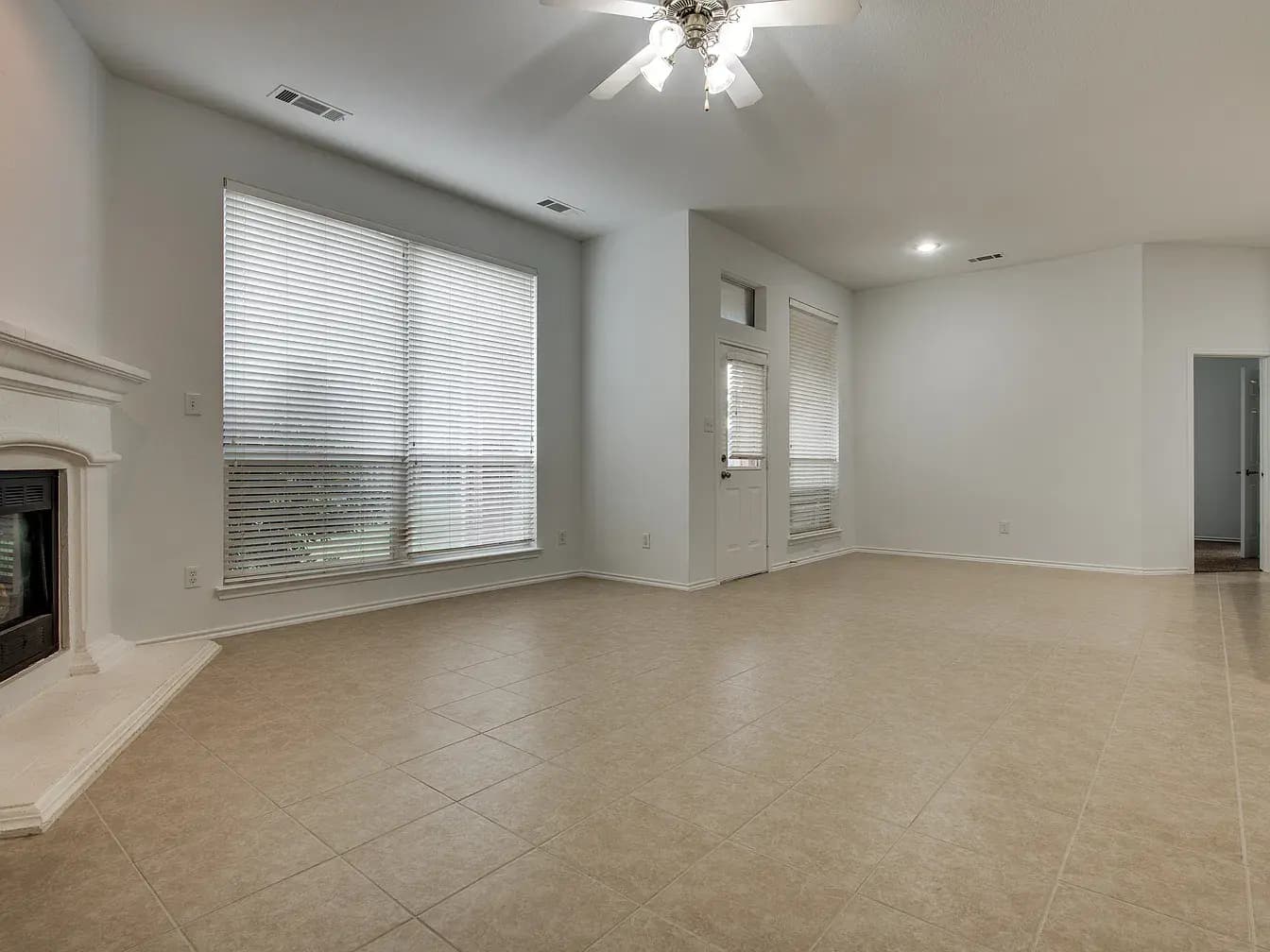 Living room with corner fireplace and tile floors